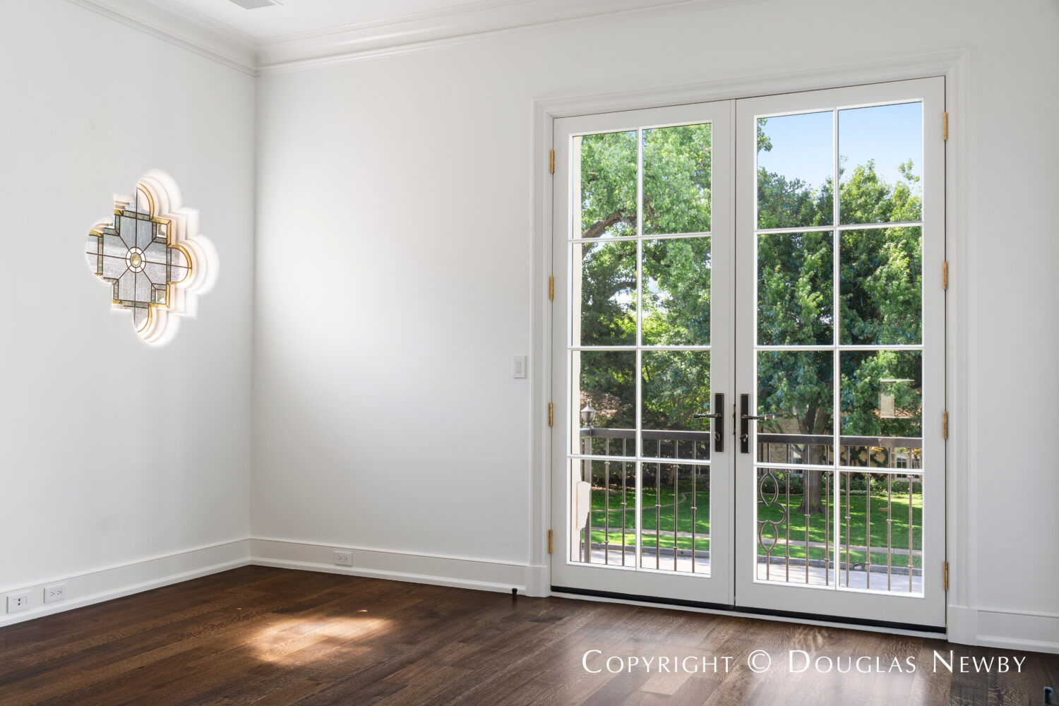 Bedroom of Highland Park estate home at 4400 Belfort Place looks out over balcony into Highland Park neighborhood in Dallas, Texas. 